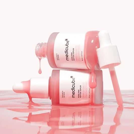 Two Medicube PDRN Pink Peptide Serum bottles with the pink serum dripping from a raised dropper, the salmon-derived PDRN serum this guide explains